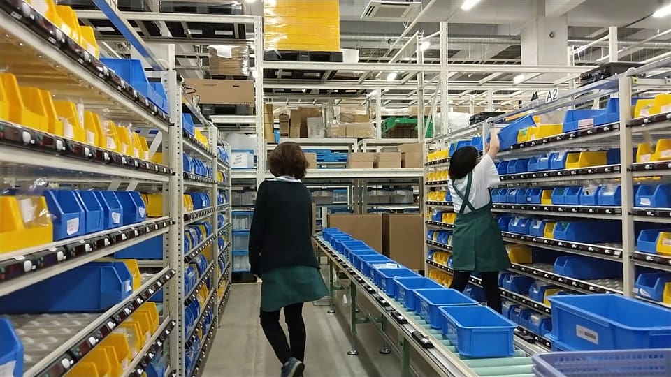 Two women are working in a warehouse.