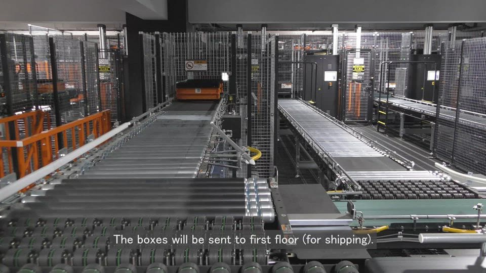 A large metal conveyor belt with boxes on it.