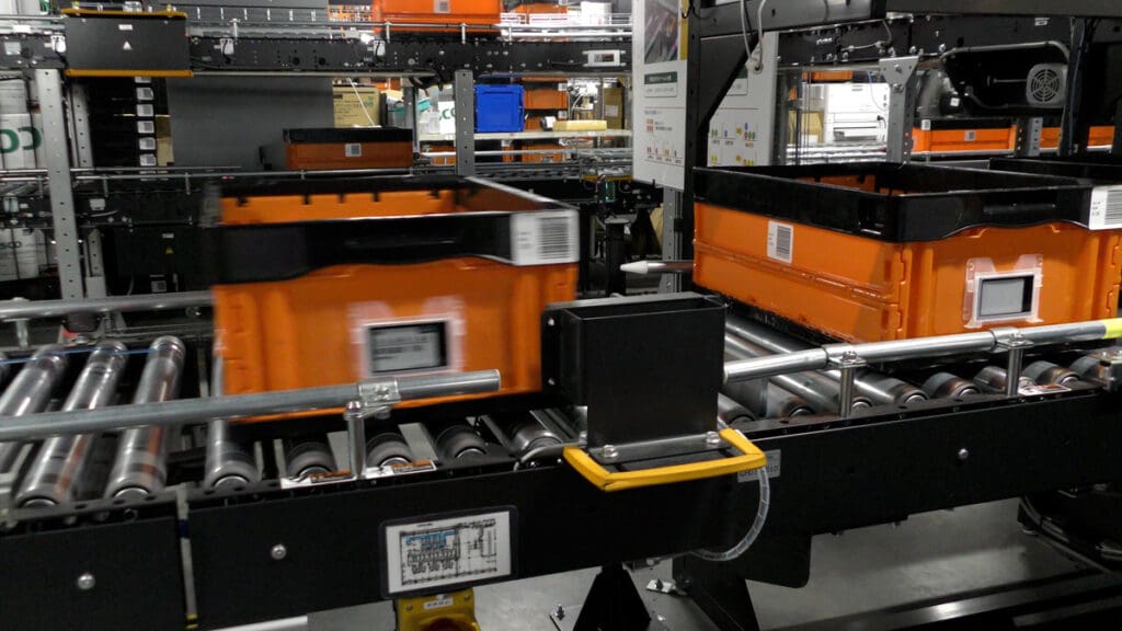 A computer monitor sitting on top of an orange machine.