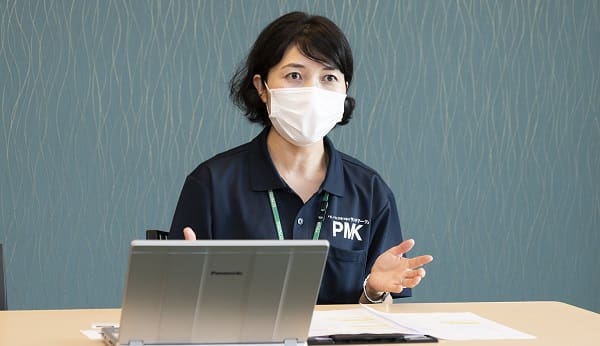 A person wearing a mask sitting at a table