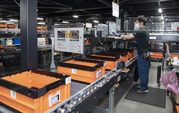 A man working in an industrial setting with boxes.