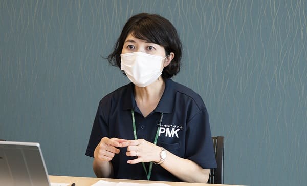 A woman wearing a mask sitting at a table.